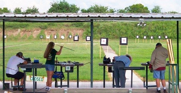 people at a gun range loading their equipment