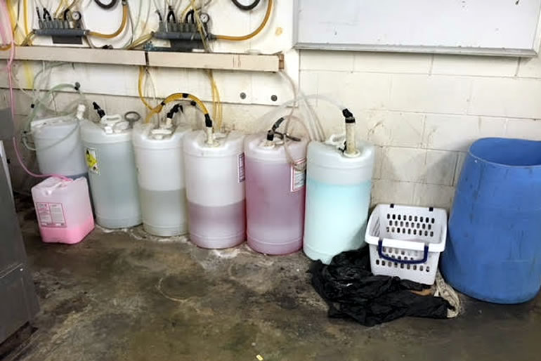 various tanks of chemicals in a dry cleaners' wash room