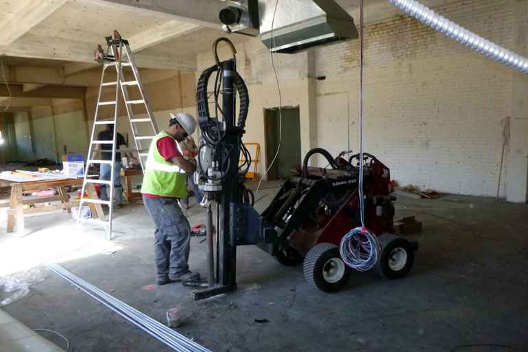 drillers setting up their equipment to drill concrete inside a building